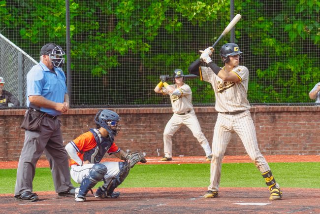 A Baseball Player Swinging A Bat At A Ball