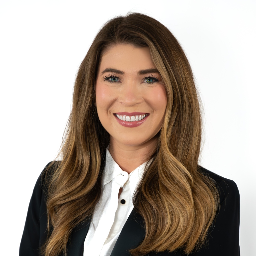 a person wearing a suit and smiling at the camera